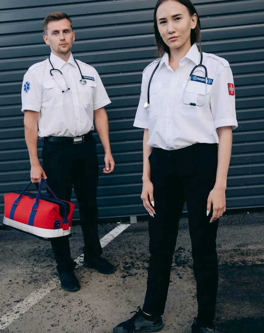 Two clinicians in uniform with a trauma bag